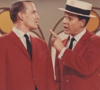 Tom (left) and Dick (right) in their iconic red jackets on The Smothers Brothers Comedy Hour. Their act frequently included onstage bickering.